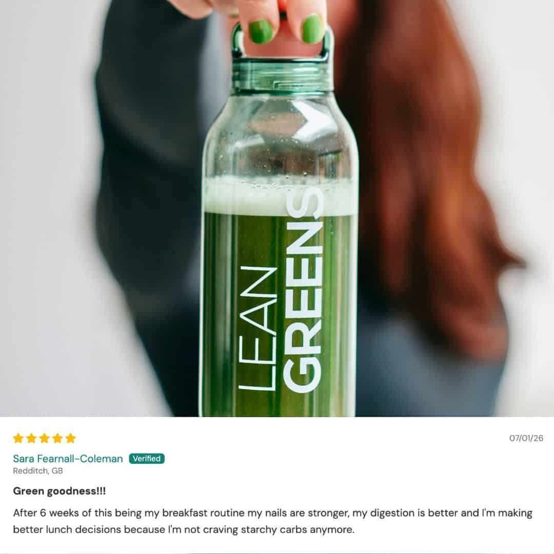 W/Lean Greens super greens powder in a clear bottle with green lid, mixed with water. A daily nutrition supplement.