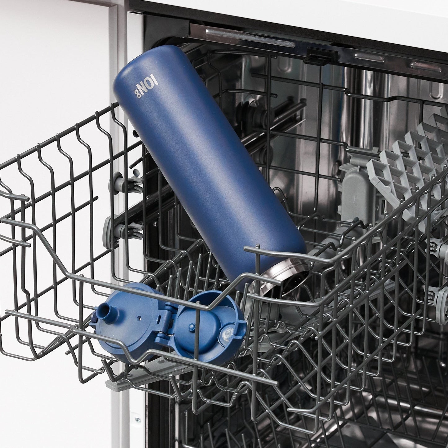 W/end ION8 1L Navy blue stainless steel thermal water bottle with flip lid, placed in dishwasher.